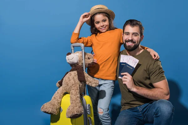 Vater und Tochter mit Reisepässen und Fahrkarten auf blauem Grund — Stockfoto