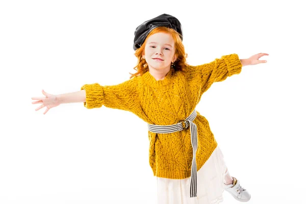 Red hair child standing on one leg with open arms isolated on white — Stock Photo