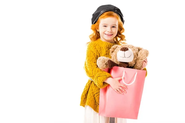 Rotes Haar Kind hält Teddybär in Einkaufstasche isoliert auf weiß — Stockfoto