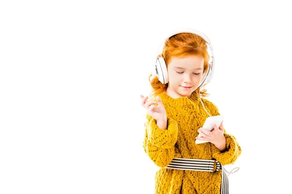 Criança cabelo vermelho ouvir música com smartphone isolado no branco — Fotografia de Stock