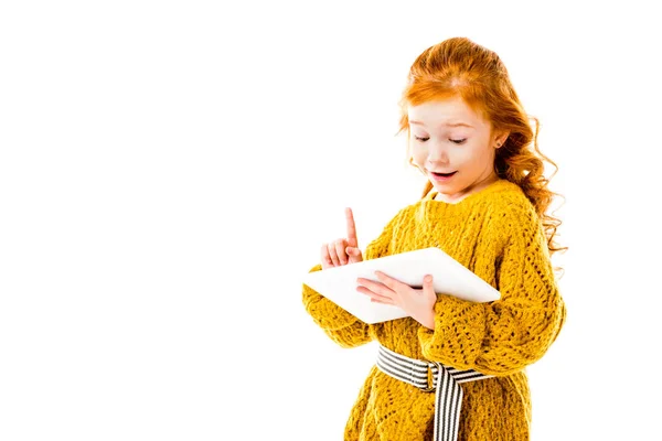 Redhead kid showing idea gesture and looking at tablet isolated on white — Stock Photo