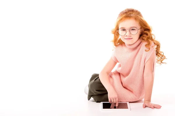 Red hair kid sitting with tablet on white — Stock Photo