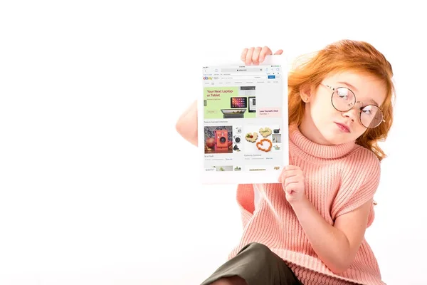 Niño de pelo rojo sentado y mostrando página ebay cargado en la tableta aislado en blanco - foto de stock