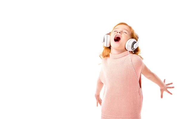 Criança cabelo vermelho em fones de ouvido gritando e dançando isolado no branco — Fotografia de Stock