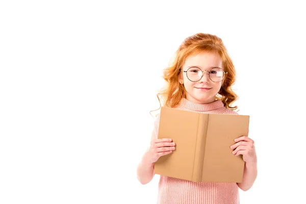Criança cabelo vermelho de pé com livro aberto isolado em branco — Fotografia de Stock