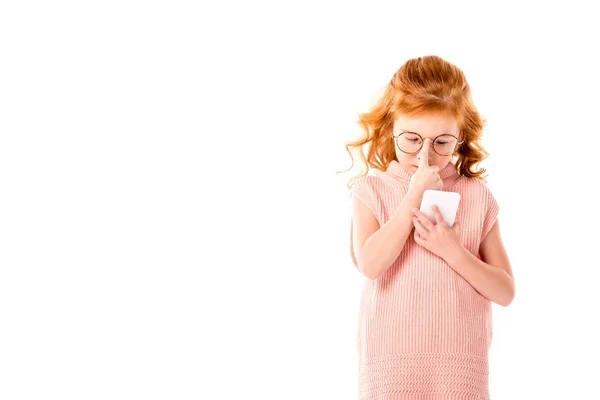 Niño de pelo rojo reflexivo mirando teléfono inteligente aislado en blanco - foto de stock