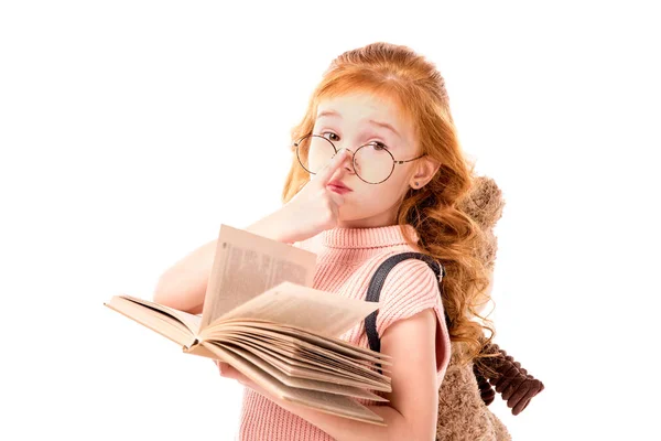 Réfléchi cheveu rouge enfant tenant livre isolé sur blanc — Photo de stock