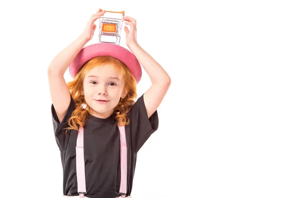 Drôle enfant tenant shopping voiture jouet sur la tête isolé sur blanc — Photo de stock