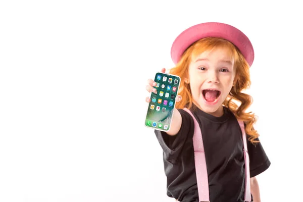 Elegante bambino in cappello rosa e bretelle mostrando smartphone con programmi icone isolate su bianco — Foto stock