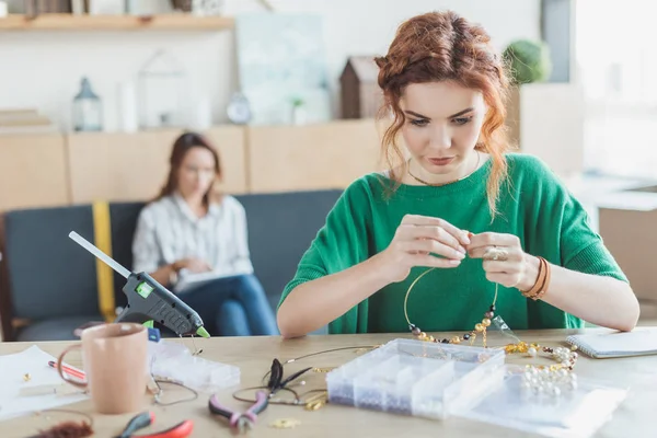 Schöne junge Frau bastelt Halskette bei Workshop — Stockfoto