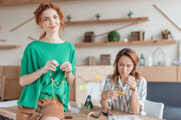 Beautiful young women with handmade accessories in workshop — Stock Photo