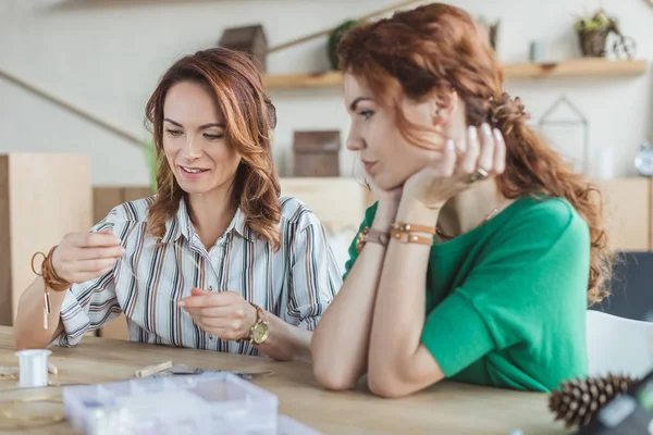 Mulheres jovens felizes que trabalham na oficina de acessórios artesanais — Fotografia de Stock