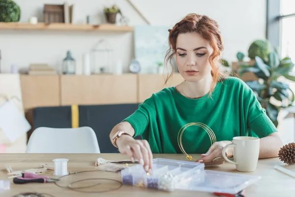 Young woman making necklaces in handmade workshop — Stock Photo