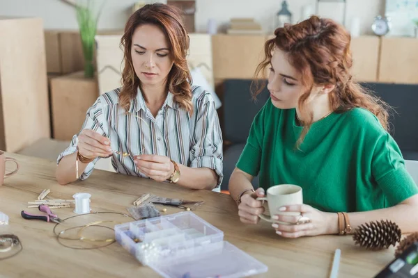 Concentrated young women making accessories in workshop — Stock Photo