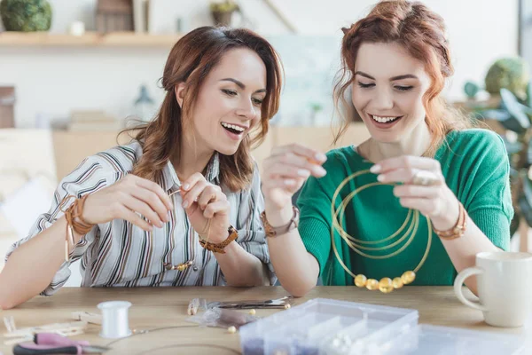 Mulheres felizes animado fazendo acessórios na oficina — Fotografia de Stock