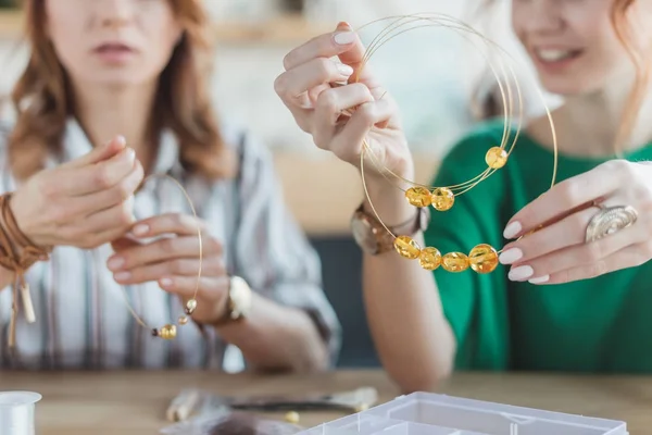 Young concentrated women making chaplets in handmade workshop — Stock Photo