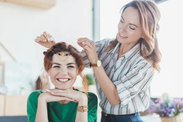 Junge Frauen probieren bei Workshop selbstgebasteltes Haarband an — Stockfoto