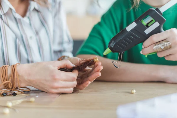 Copped shot of women making accessory with glue gun — Stock Photo