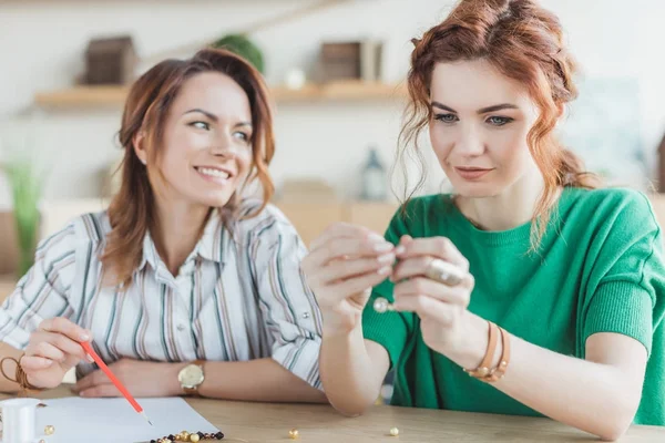 Mulheres jovens montagem acessórios de contas na oficina — Fotografia de Stock