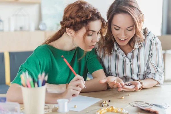 Junge Frauen arbeiten in der Werkstatt für handgefertigte Accessoires mit Perlen — Stockfoto