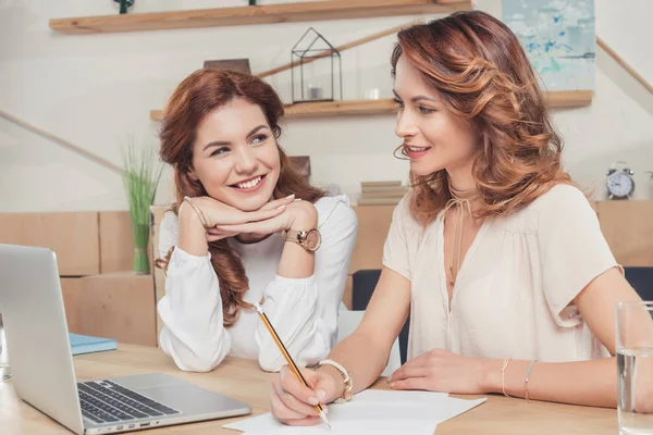 Glückliche junge Geschäftsfrauen, die im Büro zusammenarbeiten — Stockfoto