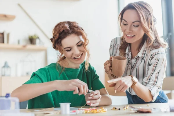 Glückliche junge Frauen basteln in Werkstatt Accessoires mit Linienzange — Stockfoto