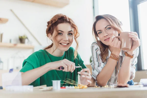 Excité les jeunes femmes faisant des accessoires en atelier — Photo de stock