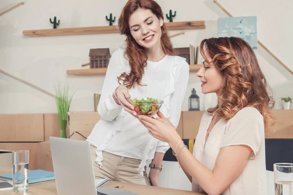 Молодая предпринимательница дает здоровый салат коллеге — стоковое фото