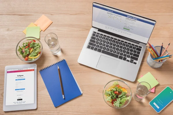 Top view of workplace with digital devices and healthy salad on desk — Stock Photo