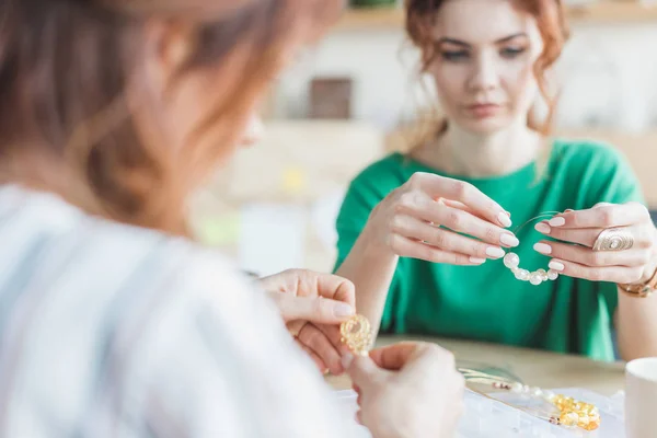 Focused young women making accessories at workshop — Stock Photo