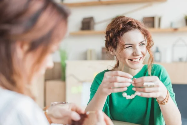 Sonrientes mujeres jóvenes haciendo accesorios en el taller - foto de stock