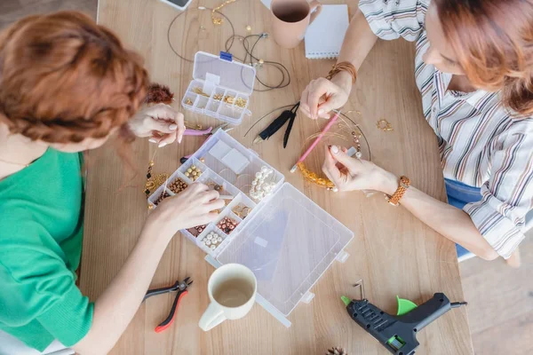 Vista de ángulo alto de las mujeres jóvenes en taller de accesorios hechos a mano - foto de stock