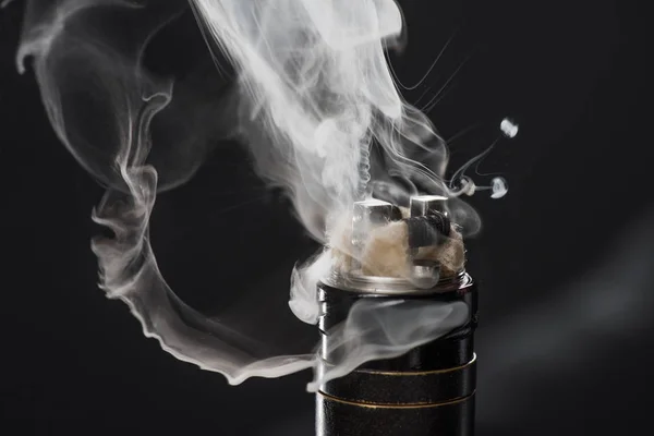 Activación de cigarrillo electrónico con nubes de humo sobre fondo oscuro - foto de stock