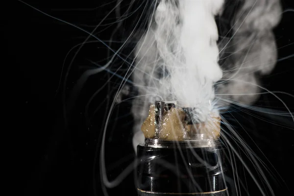 Activación de cigarrillo electrónico con nubes de humo sobre fondo oscuro - foto de stock