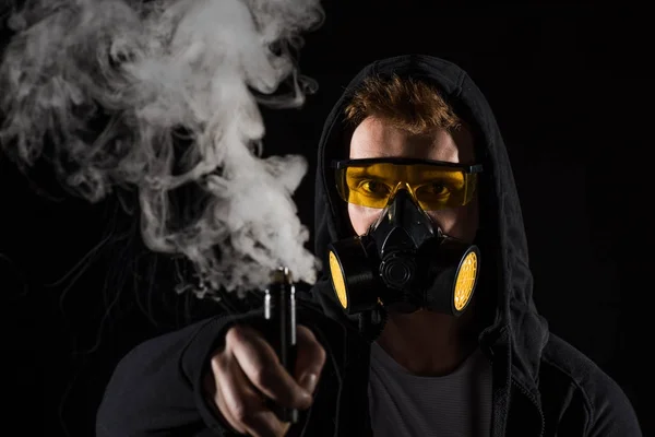 Man wearing protective filter mask activating electronic cigarette — Stock Photo