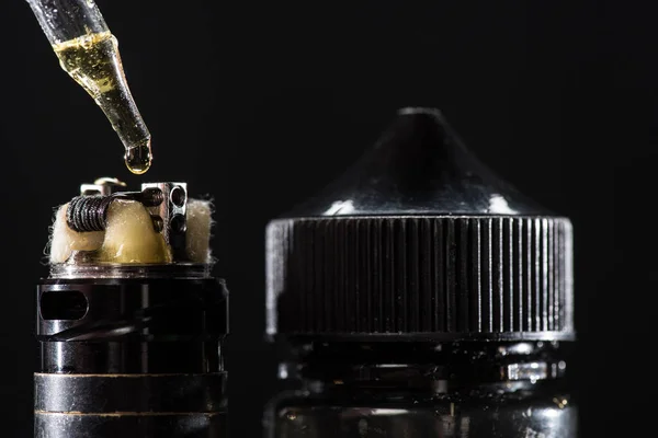 Vue rapprochée du remplissage de cigarette électronique avec e-liquide isolé sur noir — Photo de stock