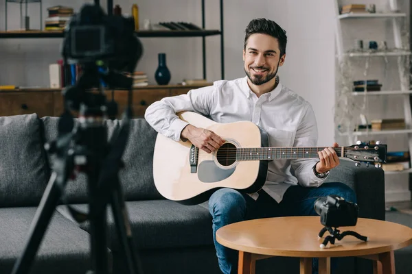 Heureux blogueur de musique jouant de la guitare acoustique — Photo de stock