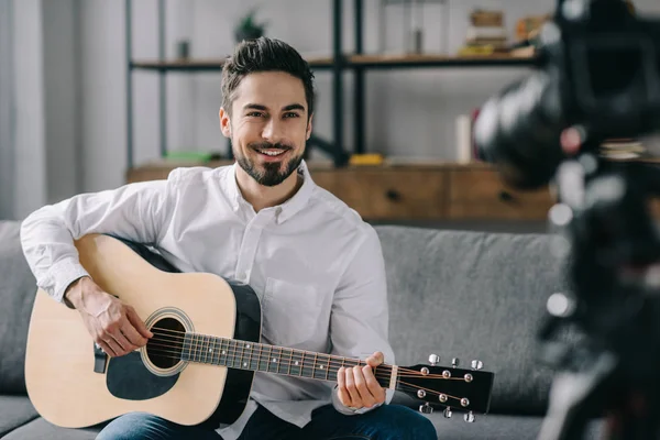 Handsome music blogger playing acoustic guitar — Stock Photo