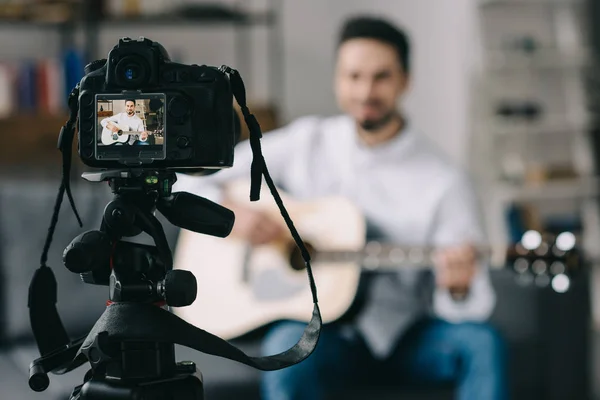 Musikbloggerin spielt Akustikgitarre vor der Kamera — Stockfoto