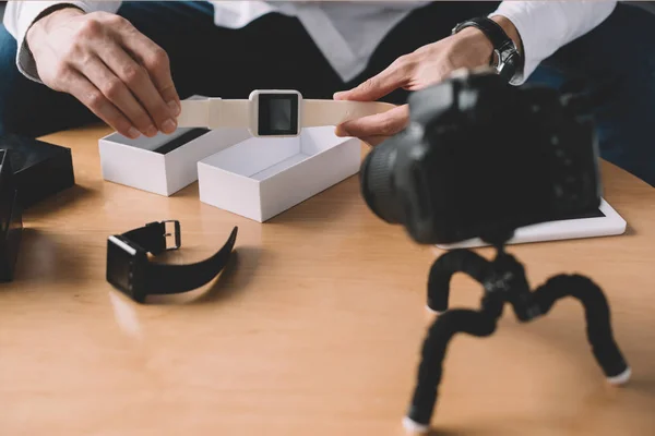 Immagine ritagliata della tecnologia blogger tenendo il nuovo orologio intelligente di fronte alla fotocamera — Foto stock