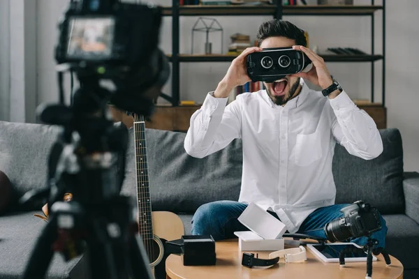 Sorprendido blogger tecnología probando auriculares de realidad virtual - foto de stock