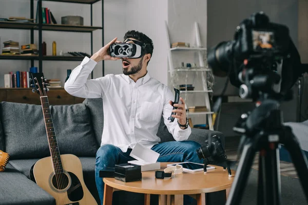 Sorprendido blogger tecnología probando auriculares de realidad virtual - foto de stock
