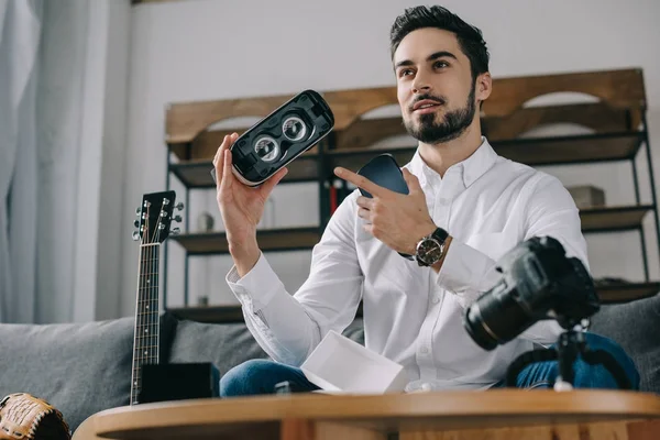 Blogger de tecnología apuntando a auriculares de realidad virtual - foto de stock