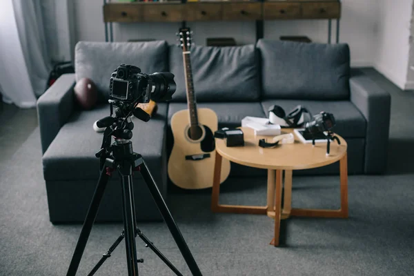 Guitare acoustique et caméras avec table en bois dans une pièce vide — Photo de stock
