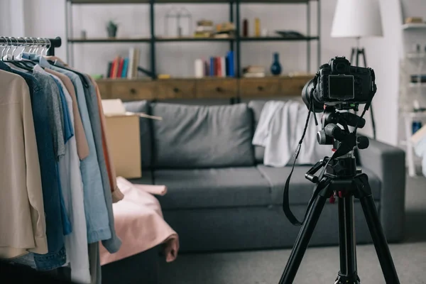 Different clothes on hangers on stand in empty room — Stock Photo