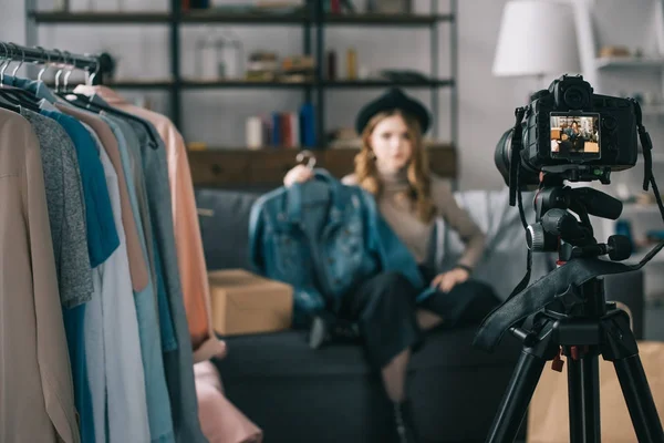 Blogger de moda grabando un nuevo vlog sobre jean jacket con cámara en primer plano - foto de stock