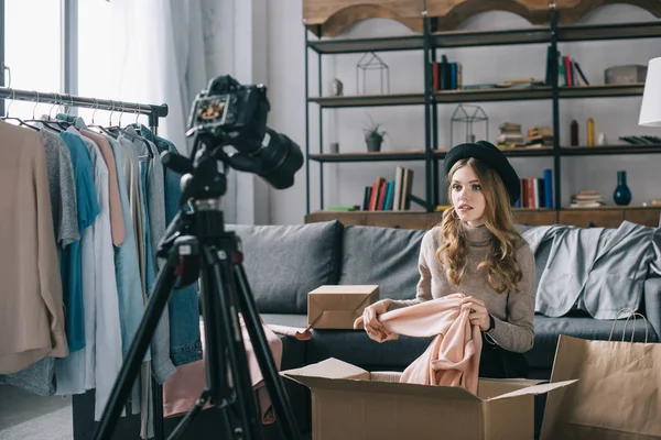 Young fashion vlogger sitting in front of camera with shirt — Stock Photo