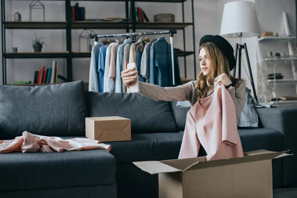 Blogueur de mode tenant robe et prendre selfie avec smartphone — Photo de stock