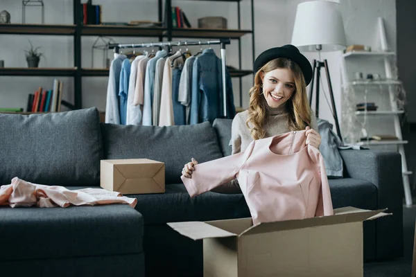 Smiling fashion blogger holding dress — Stock Photo