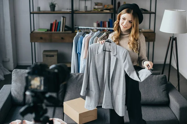 Sonriente blogger de moda grabando nuevo vlog sobre chaqueta - foto de stock